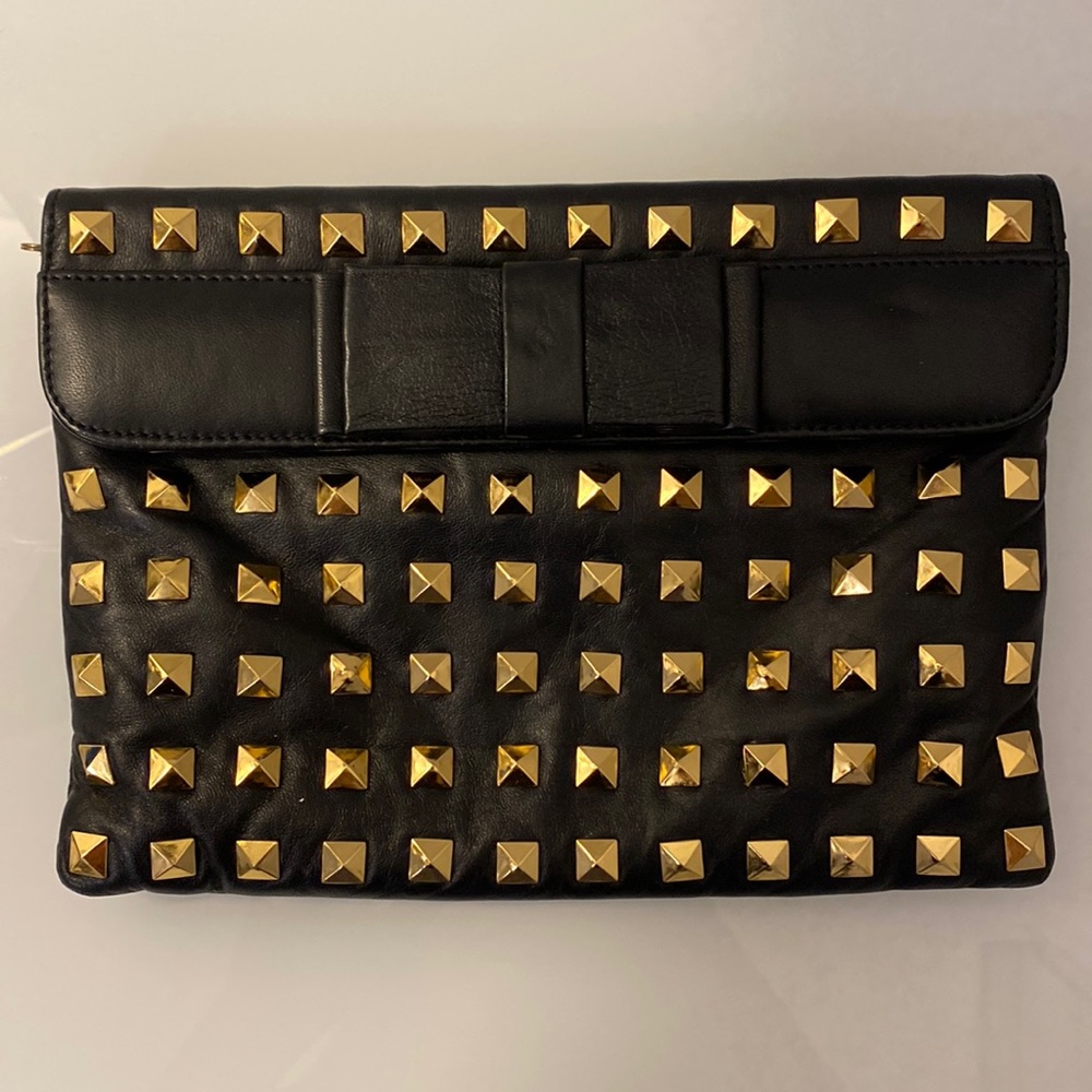 Black purse with gold studs and thin gold strap